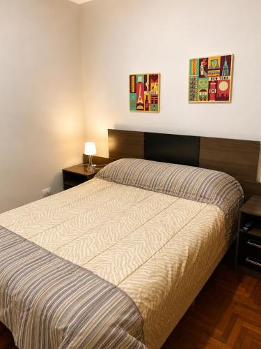 a bedroom with a bed and two pictures on the wall at Alto Belgrano II in Mendoza