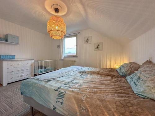 a bedroom with a large bed and a chandelier at Großlangenfeld in Großlangenfeld