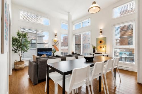 a living room with a table and chairs and a couch at LiV MTL Main Plateau Suites Near Downtown Montreal in Montreal