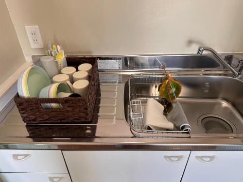 a kitchen sink with dishes and a dish rack in it at Prince Plage OKINAWA 6F in Fuzuchi