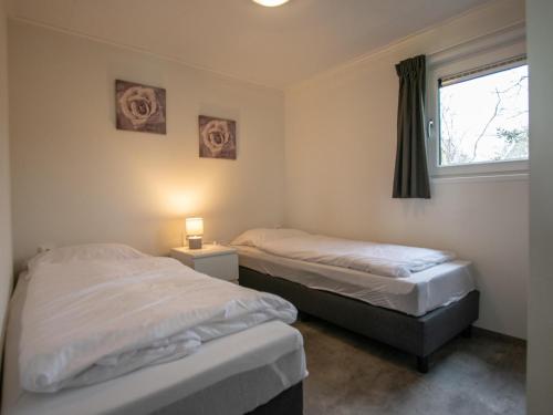 two beds in a room with a window at De Zwaluw in Heiloo