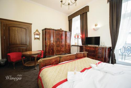sypialnia z łóżkiem, stołem i telewizorem w obiekcie Sempre B&B w mieście Płock