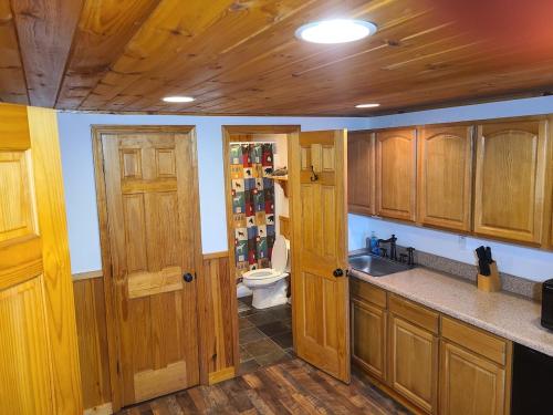 a kitchen with wooden cabinets and a toilet at Further Up & Further In in Topton