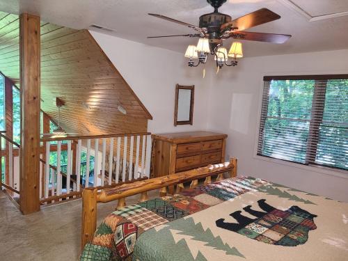 a bedroom with a bed and a ceiling fan at Further Up & Further In in Topton