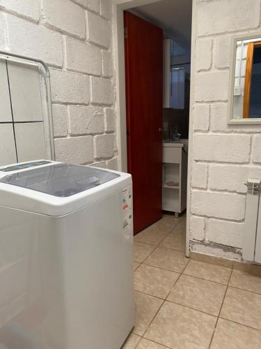 a white appliance in a kitchen with a brick wall at Los Duraznillos in Los Antiguos