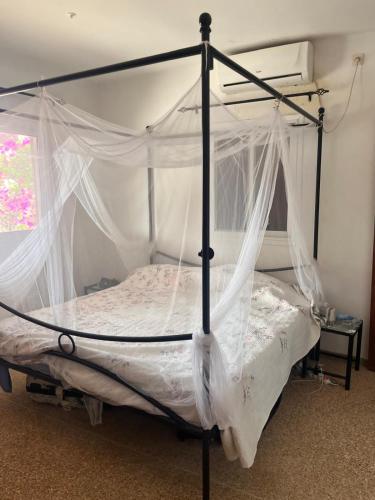 a bedroom with a canopy bed with mosquito nets at Villa Farou in Mbour