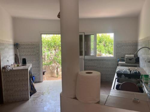 a white kitchen with a sink and a counter at Villa Farou in Mbour