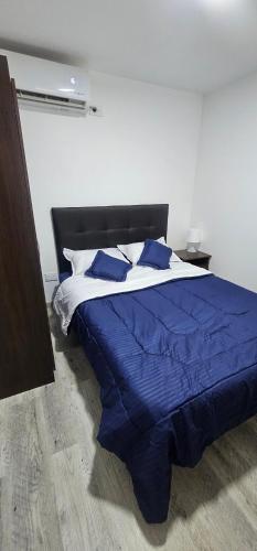 a bedroom with a bed with blue sheets and pillows at Balcones de las lajas in Cali