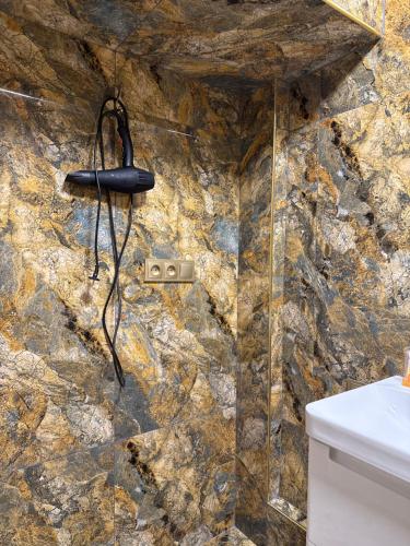 a stone bathroom with a phone on a wall at Абдрахманова 176 in Bishkek