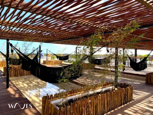 a patio with a hammock and a table with plants at Amelia By Waves in Tulum