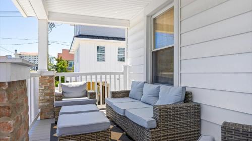 a porch with wicker chairs and a couch at 5BR plus Den - Downtown OC - Sleeps 16 in Ocean City