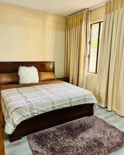 a bedroom with a bed with a rug and a window at Mosia Guest House in Maseru