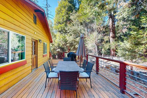 a table and chairs on a deck with an umbrella at Casa Tahquitz in Idyllwild