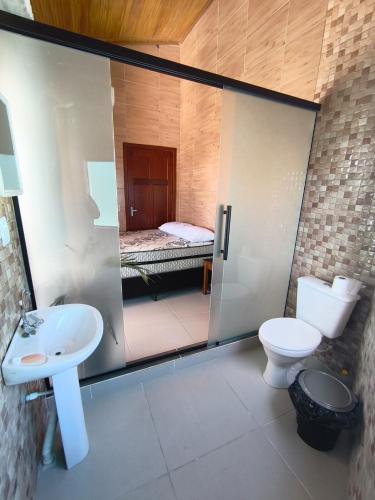 ein Badezimmer mit Dusche, Toilette und Waschbecken in der Unterkunft Mar e lar e lazer in Pinheira