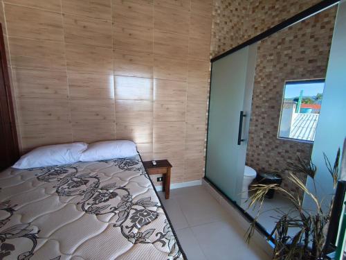 ein Schlafzimmer mit einem Bett und einer Holzwand in der Unterkunft Mar e lar e lazer in Pinheira