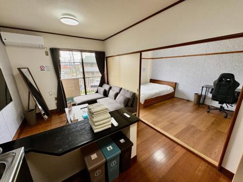 a small room with a couch and a mirror at Stay Plus Azunoa in Oyama