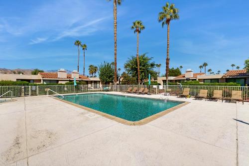 a swimming pool in a resort with palm trees at Palm Paradise in Palm Desert