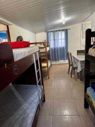 a room with a bunk bed and a dining room at Abrigo e Camping Recanto das Arvores in Itamonte