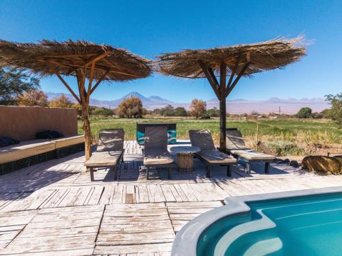 a patio with chairs and a table next to a pool at Atacama Loft & Glamp in San Pedro de Atacama