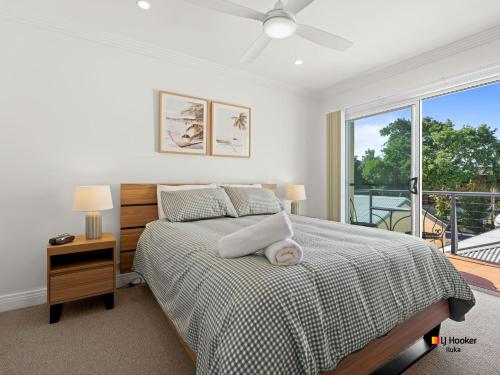 a bedroom with a bed and a large window at Riverview Apartment 1.4 in Iluka