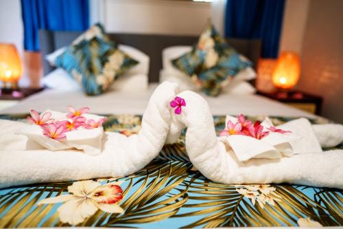 two swans made out of towels on a bed at E' Nauwi Beach Resort in Port Vila