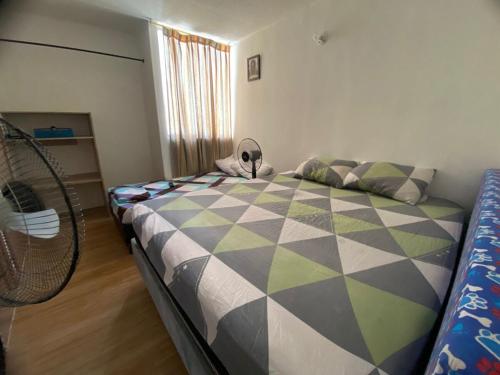 a bedroom with a bed with a comforter on it at Apartamento en Melgar con la mejor ubicacion in Melgar