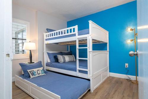 a bedroom with a white bunk bed with blue walls at Lakeview 2 suites 6 min to New EPIC Universe in Orlando