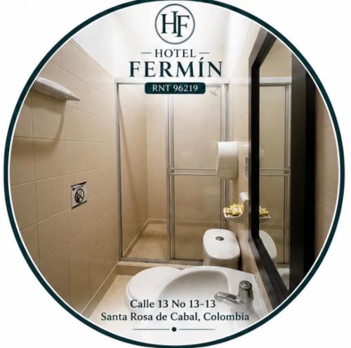 a round mirror in a bathroom with a toilet at Hotel Fermín in Santa Rosa de Cabal
