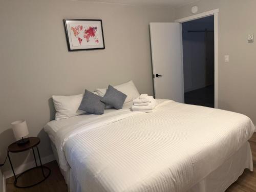 a bedroom with a white bed with blue pillows at Supinder's Rentals in Golden