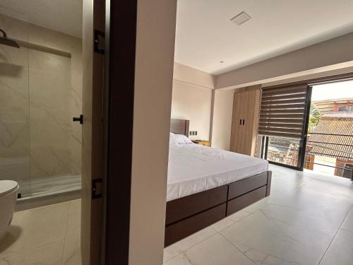 a bedroom with a bed and a shower and a window at Torre OCEAN DRIVE in Montañita