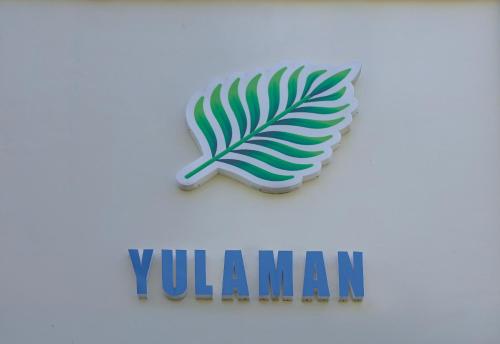a sign for a venezuelan company with a palm leaf at Yulaman Hotel in Gili Trawangan