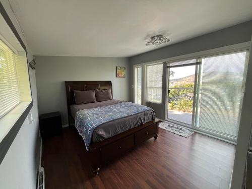 a bedroom with a bed in a room with windows at Lantzbnb front view in Lantzville