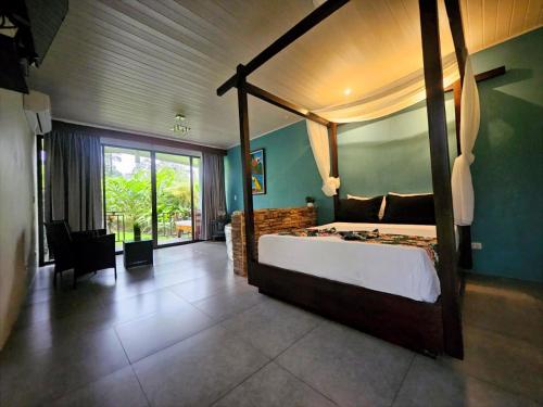 a bedroom with a canopy bed and a large window at Yellow Tree Suites in Fortuna
