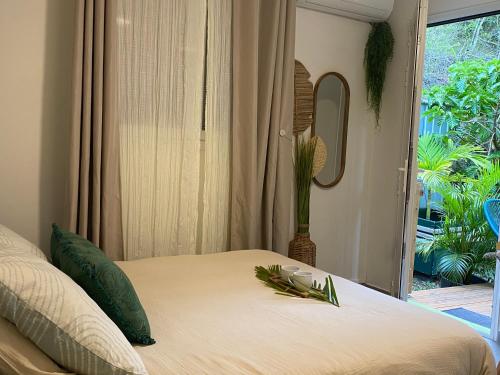 a bedroom with a bed with a plant on it at L'Isménia, L'écrin Zen in Le Gosier