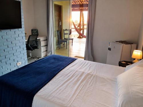 a bedroom with a bed with a blue and white blanket at Casa da Praia Costazul in Rio das Ostras