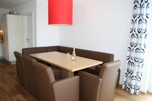 a dining room with a wooden table and chairs at Ferienresidenz Leogangerhof in Leogang