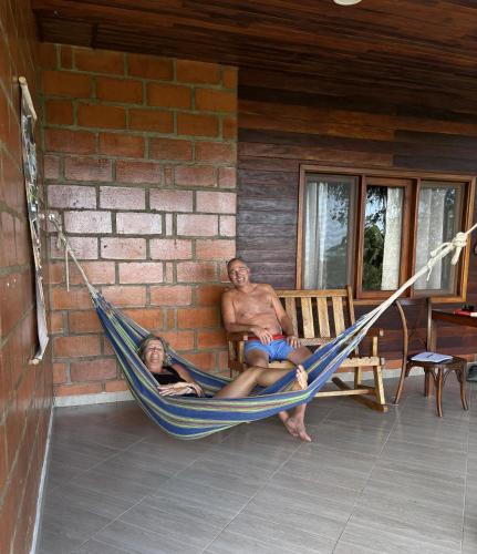 a man and a girl sitting in a hammock at Promisedland Tayrona Cabins Hotel in Buritaca