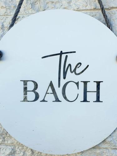 a sign that reads the bat on a wall at The Bach - Pohara in Pohara