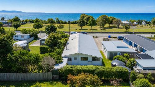an aerial view of a house with the ocean in the background at The Bach - Pohara in Pohara
