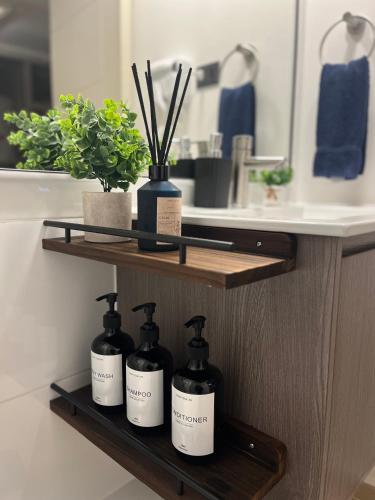 a bathroom with three bottles of soap on a shelf at Exclusivo departamento in Valdivia