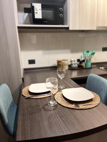 a table with two plates and wine glasses on it at Exclusivo departamento in Valdivia