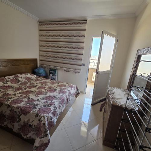a bedroom with a bed and a window and a mirror at Lmadghri6 in Ras El Ma
