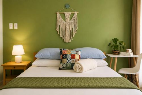 a bedroom with a bed with green walls at Hooga Home in Cebu City