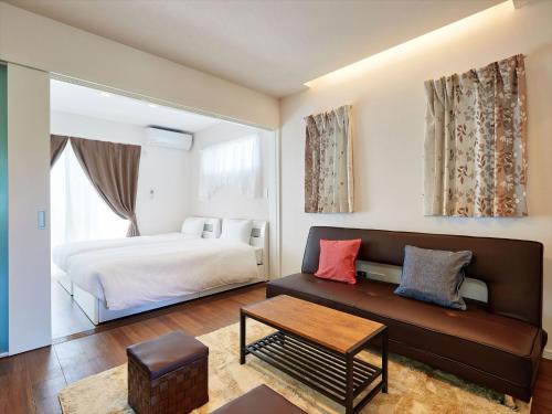 a bedroom with a bed and a couch at Condominium・yuyuki in Yomitan