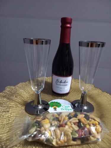 a bottle of wine and two glasses on a table at Casa del Bosque in Mocoa