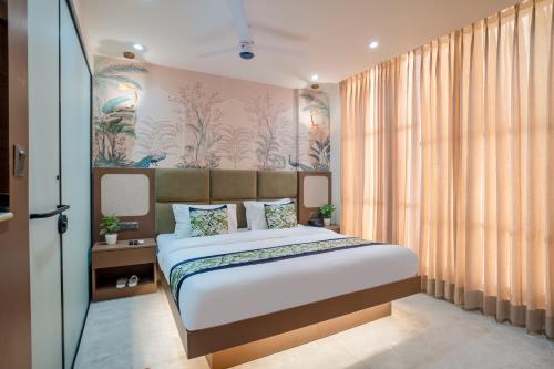 a bedroom with a bed and a large window at Hotel IKOY A Luxury Boutique Near Ashok Vihar & Model Town in New Delhi