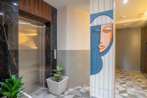a painting of a woman on a wall in a lobby at Hotel IKOY A Luxury Boutique Near Ashok Vihar & Model Town in New Delhi