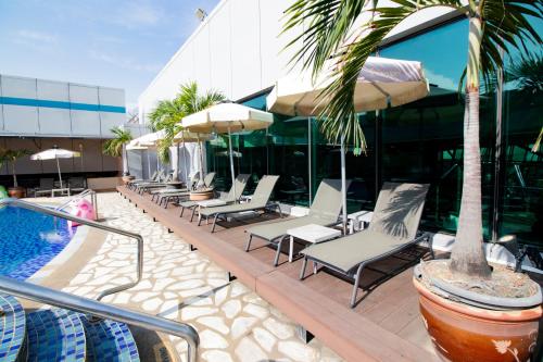 a row of chairs and umbrellas next to a pool at Changi Transit Hotel Terminal 1 in Singapore
