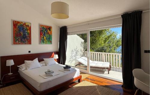a bedroom with a bed and a balcony with a sliding glass door at Villa Aqua in Vrbanj