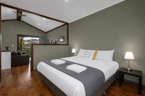 a bedroom with a large bed and a living room at Elysian Bridgetown in Bridgetown